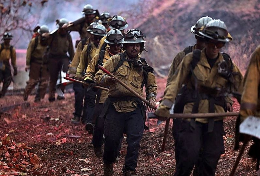 Varios bomberos caminan hacia uno de los focos 